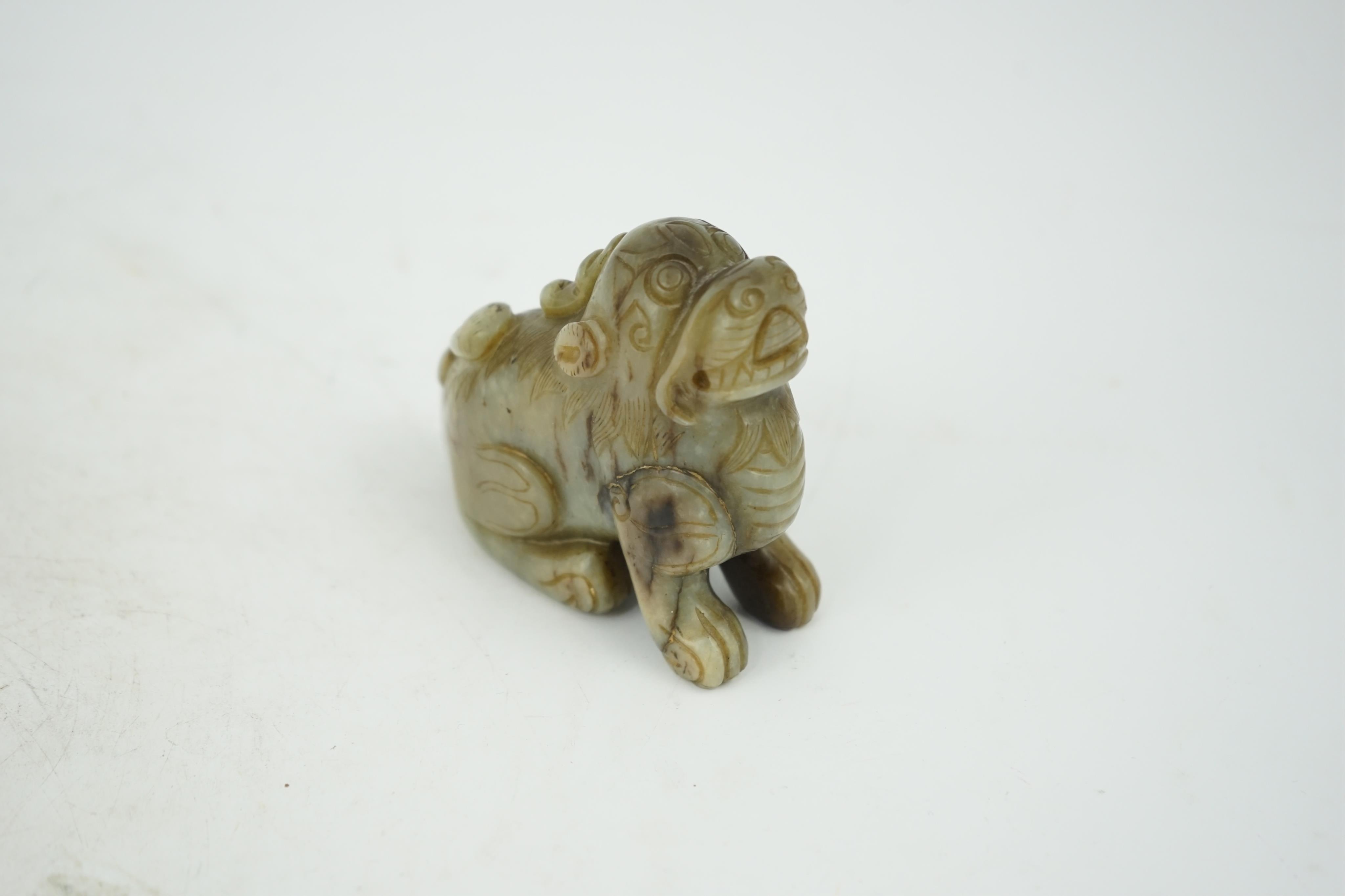 A Chinese pale grey green and black jade figure of a seated Mythical beast, Qing dynasty